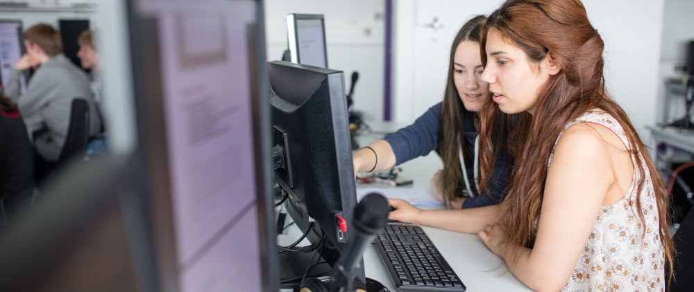 Studentinnen an Computer und Mikro