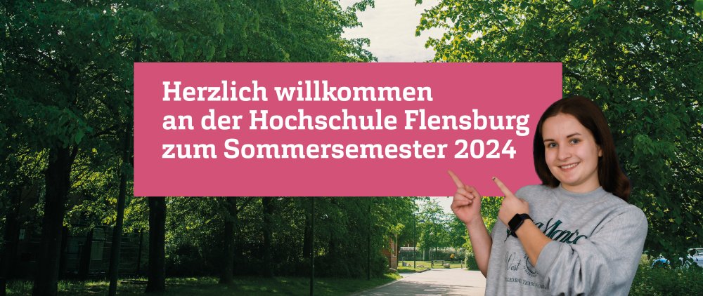 Ein gepflasterter Fußweg auf dem Flensburger Cmapus, rechts und links grün belaubte Bäume. Im Vordergrund eine junge Frau, die lächtelt und mit beiden Händen auf ein rosafarbenes Farbfeld zeigt, auf dem zu lesen ist: "Herzlich willkommen an der Hochschule Flensburg zum Sommersemester 2024"