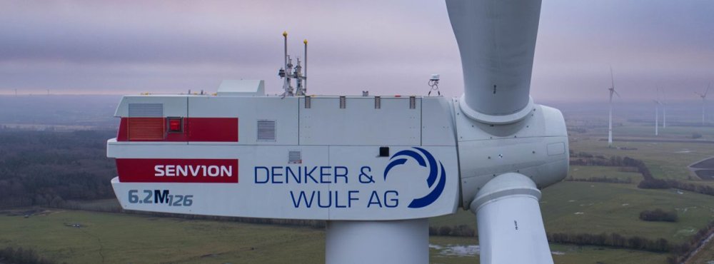 Nahaufnahme des Kopfes einer Windkraftanlage mit dem Aufdruck Denker & Wulf AG.