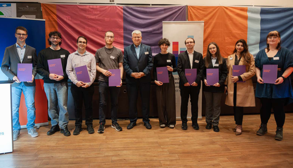 Eine Gruppe von jungen Menschen mit Urkunden in der Hand lächelt in die Kamera.