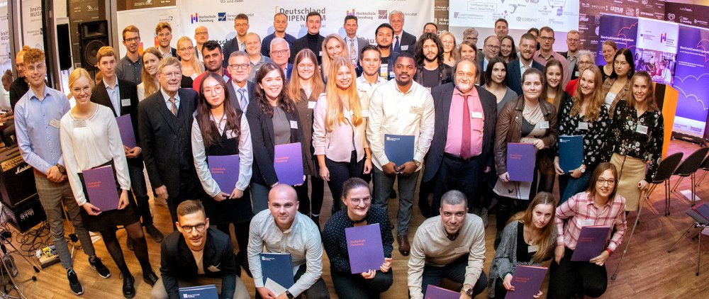 Gruppenbild zahlreicher junger Menschen, die mit Urkunden in die Kamera lächeln.