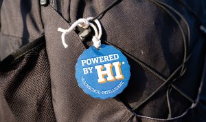 Schwarzer Rucksack mit blauem Anhänger, darauf weiße schrift: Powered by HI* - *Hochschulintelligenz