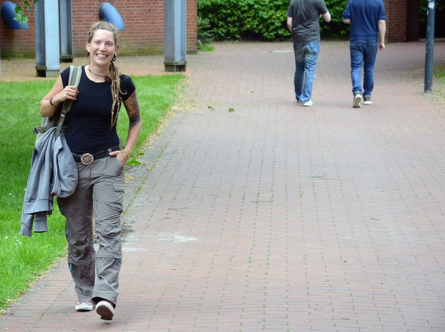 Studentin läuft über den Campus.