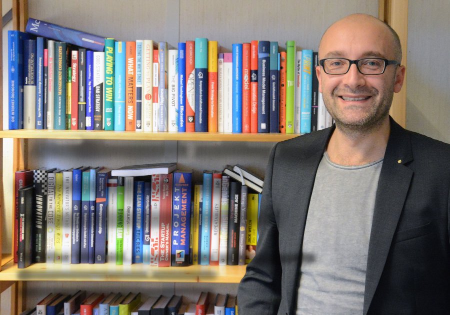 Andreas Rusnjak in seinem Büro, vor einem Bücherregal.