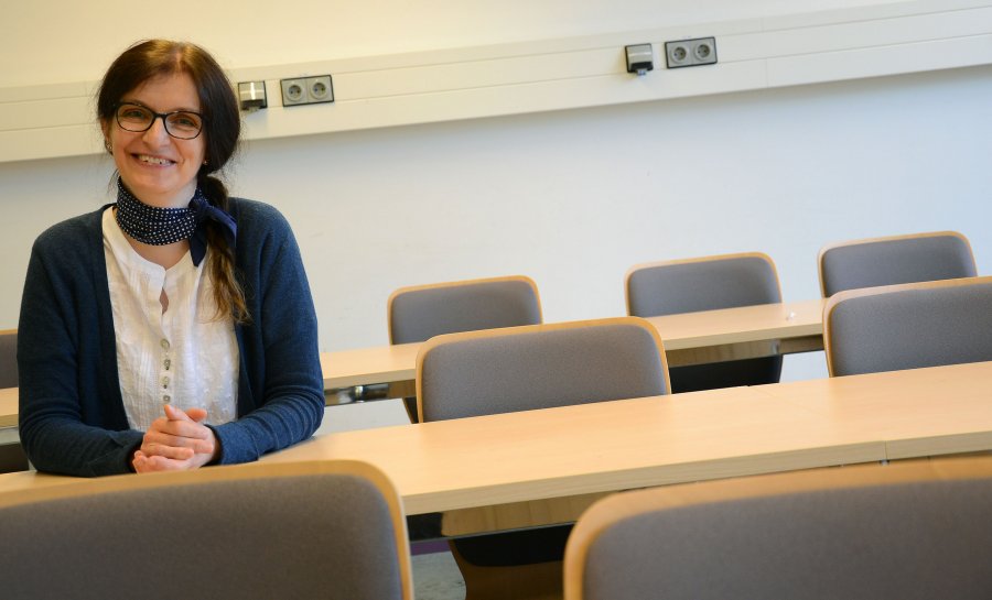 Sonja Ruda sitzt in einem Seminarraum an einem Tisch.