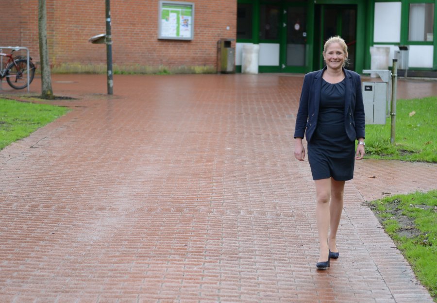 Nelly Oelze läuft über den Campus. Der Weg und die Wiese sind noch vom Regen nass.