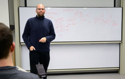 Kai Petersen vor einem Whiteboard im Seminarraum.