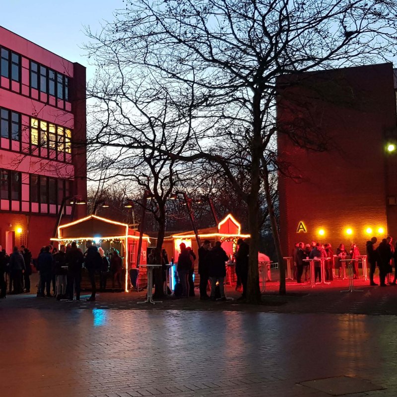 Weihnachtlich beleuchteter Platz auf dem Campus mit Punschbuden. 
