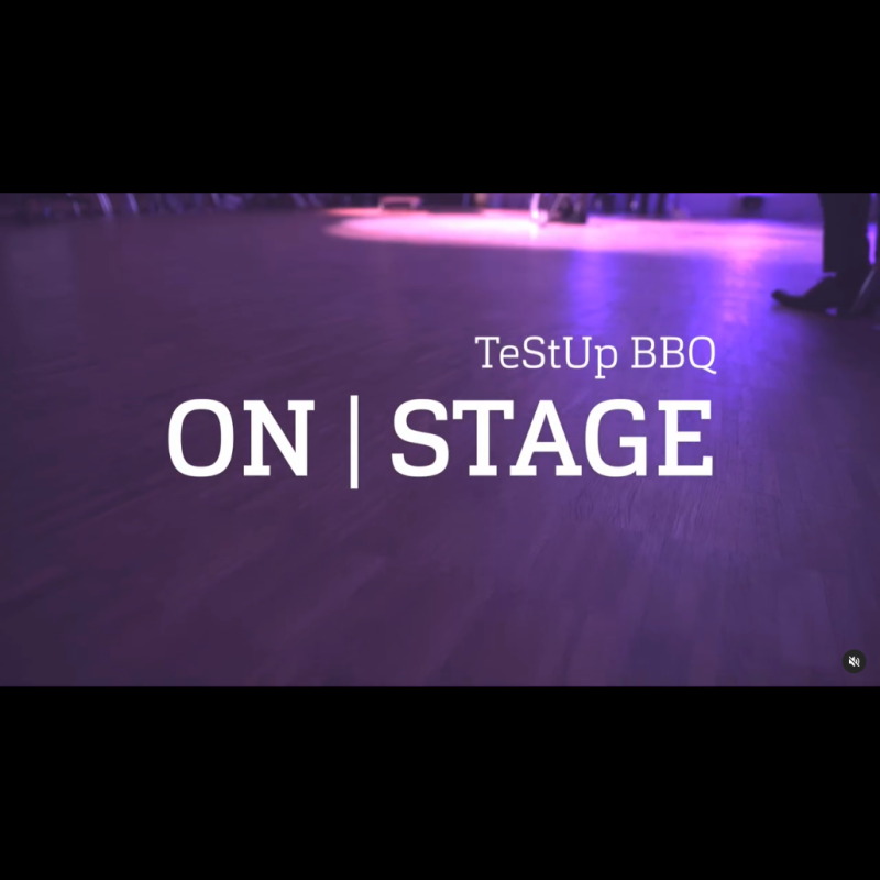 Ein lila beleuchteter Bühnen-Boden, darüber Text: "TeStUp BBQ ON | STAGE"