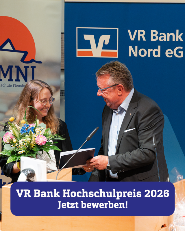 Ein Mann im Anzug schüttelt einer jungen Frau mit einem Blumenstrauß die Hand, hinter ihnen ein Roll-Up mit dem Logo der VR Bank Nord eG.