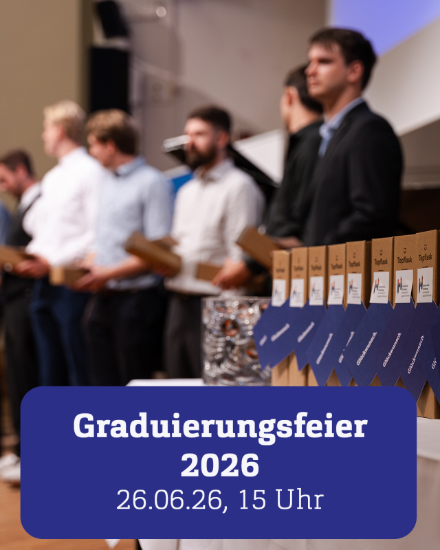 Eine Reihe von Studierenden steht auf einer Bühne, davor Kartons mit Glückwunsch-Karten.
