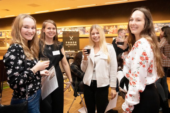 Vier junge Frauen lachen in die Kamera.