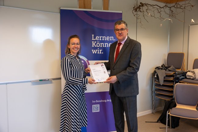 Der Vizepräsident übergibt ein Zertifikat an die Teilnehmer*innen