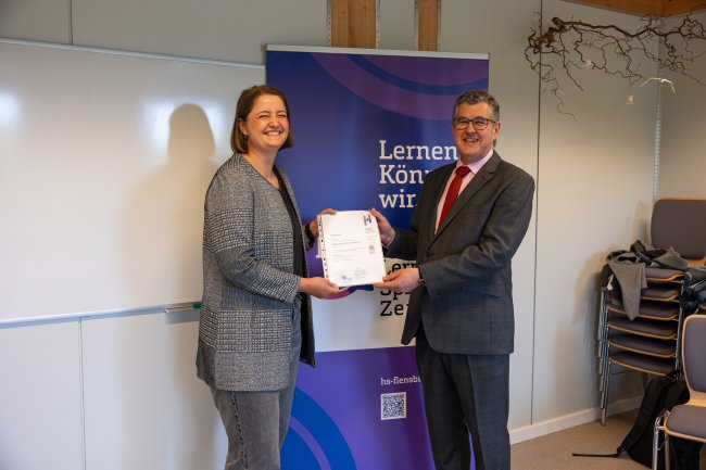 Der Vizepräsident übergibt ein Zertifikat an die Teilnehmer*innen