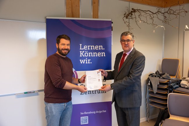 Der Vizepräsident übergibt ein Zertifikat an die Teilnehmer*innen