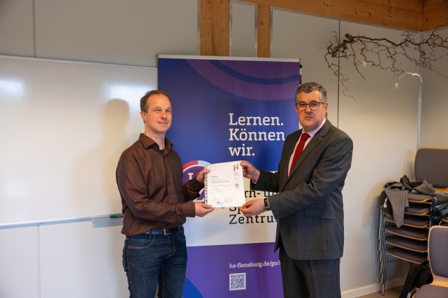 Der Vizepräsident übergibt ein Zertifikat an die Teilnehmer*innen