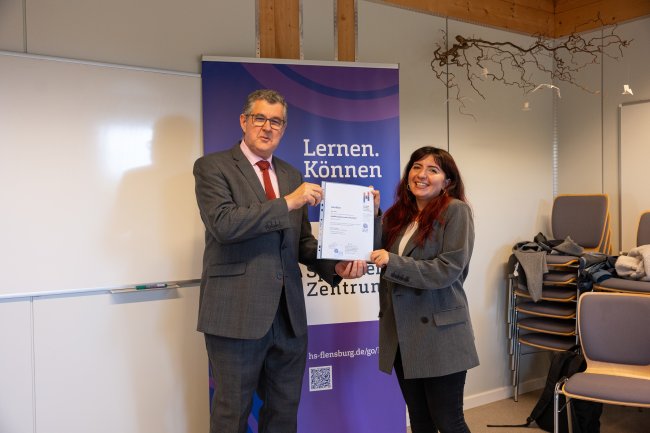 Der Vizepräsident übergibt ein Zertifikat an die Teilnehmer*innen