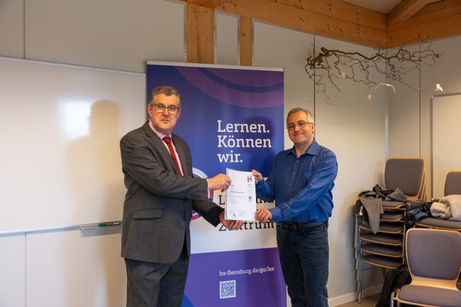 Der Vizepräsident übergibt ein Zertifikat an die Teilnehmer*innen