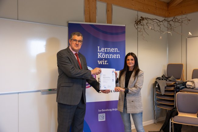 Der Vizepräsident übergibt ein Zertifikat an die Teilnehmer*innen