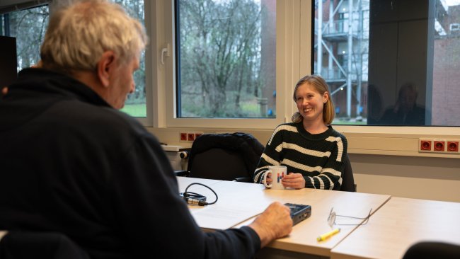 Lilith im Interview. Sie sitzt an einem Tisch und spricht in ein Mikrofon.