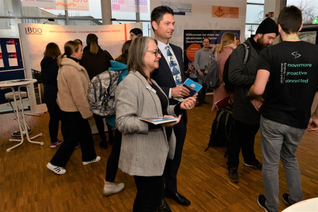 Dr. Fabian Geyer vom Arbeitgeberverband wird informiert von Organisatorin Ellen Kittel