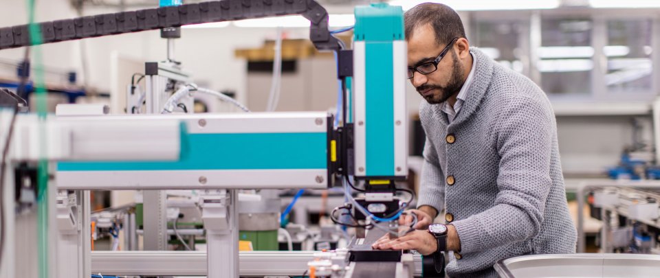 Student in a lab working on automation engineering devices.