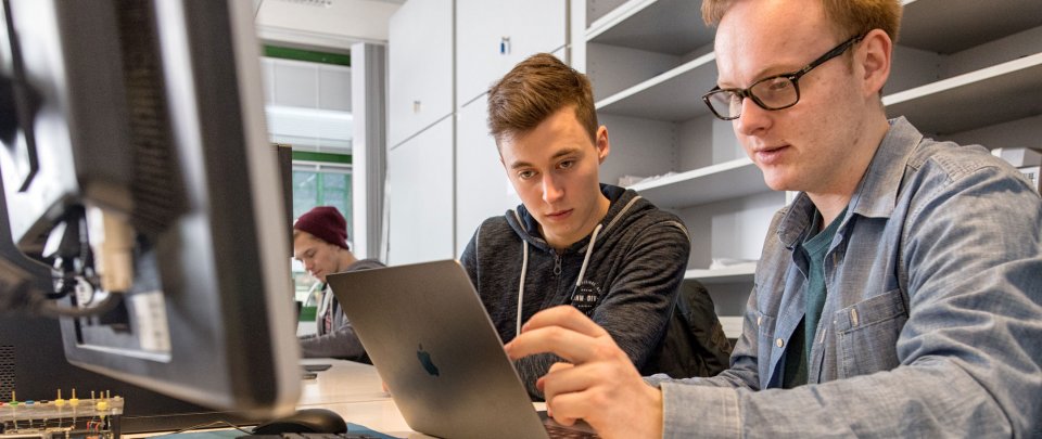 Zwei Studenten, die an einem Computer arbeiten.