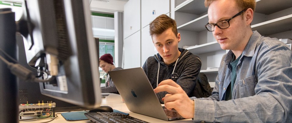 Zwei Studenten, die an einem Computer arbeiten.
