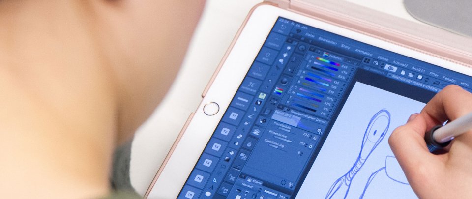 Studierender der Medieninformatik zeichnet auf einem Tablet eine Figur