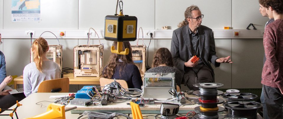 Studierende sitzen in kleinen Gruppen und diskutieren über Ihre neusten Projekte