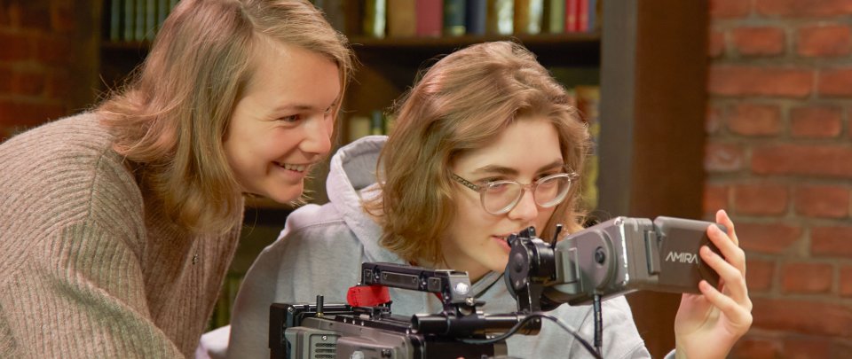 Zwei Studentinnen hinter einer Kamera.