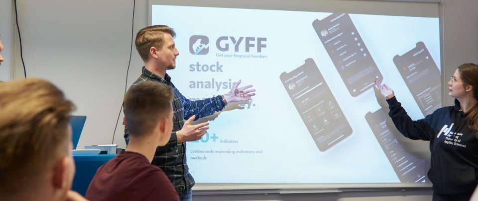 Studentin und Student halten Vortrag zu Aktienanalyse.