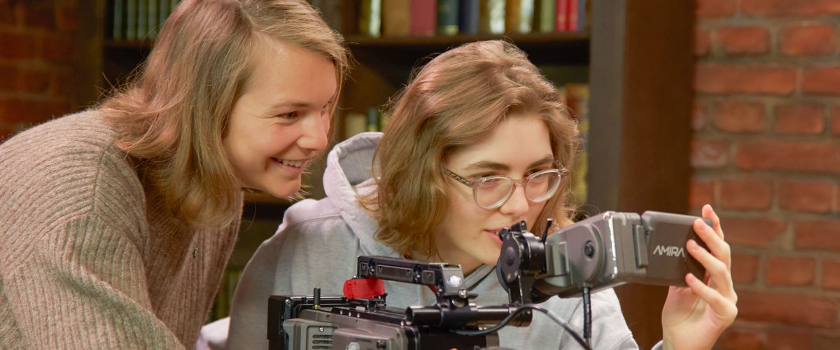 Zwei Studentinnen hinter einer Kamera.