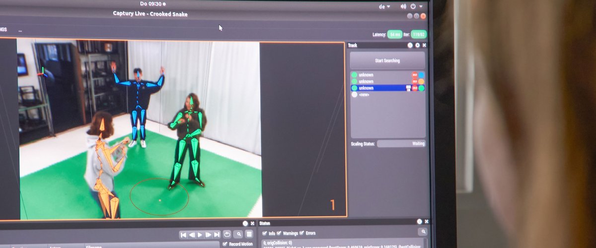 Unscharfer Kopf vor einem Bildschirm auf dem Menschen im Green Screen-Studio zu sehen sind.