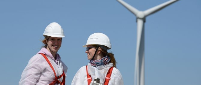Two students in front of a wind turbine.