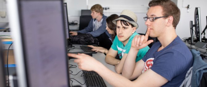 Zwei Studenten, die an einem Computer arbeiten.