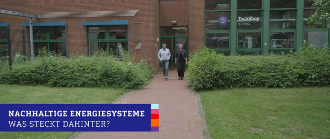 Ein Dozent und eine Studentin kommen aus einem Backsteingebäude, rechts sieht man eine Glasfassade mit der Aufschrift "TechShop - Part of TeStUp". Auf einer blauen Bauchbinde steht der Text: "Nachhaltige Energiesysteme - Was steckt dahinter"?