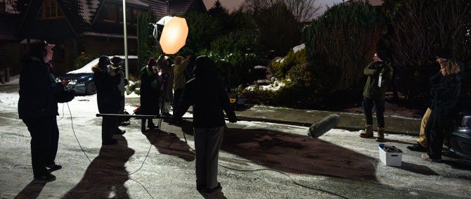 Eine Gruppe von Studierenden bei einem Filmdreh auf einer winterlich vereisten, dunklen Straße.