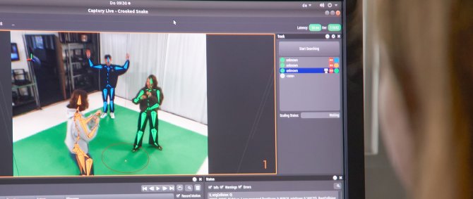 Unscharfer Kopf vor einem Bildschirm auf dem Menschen im Green Screen-Studio zu sehen sind.