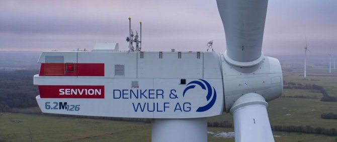 Nahaufnahme des Kopfes einer Windkraftanlage mit dem Aufdruck Denker & Wulf AG.
