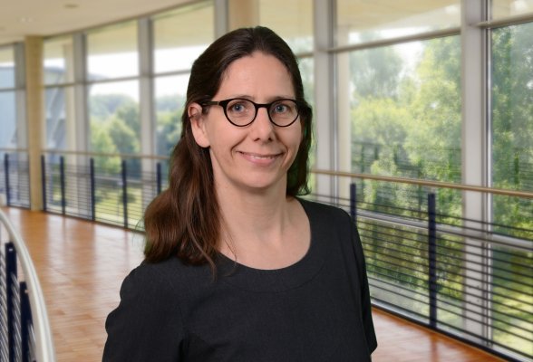 Porträtfoto: Antje Labes im audimax, sie trägt die langen, braunen Haare offen über die Schultern, eine Brille und ein dunkles Oberteil.