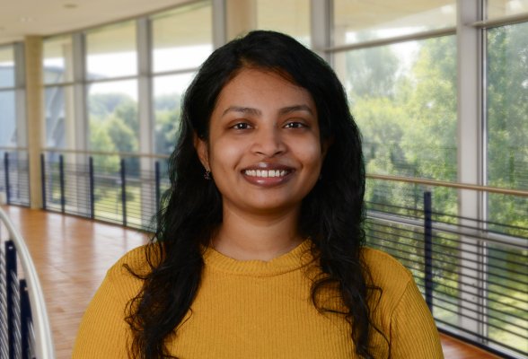 Porträtfoto: Rachana Niranjan Murthy im audimax, sie trägt die dunklen, langen Haare offen und einen senf-gelben Pullover.