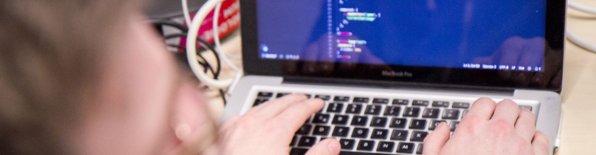 Blick auf einem Laptopmonitor, zu sehen sind einige verschwommende Zeilen Programmiercode