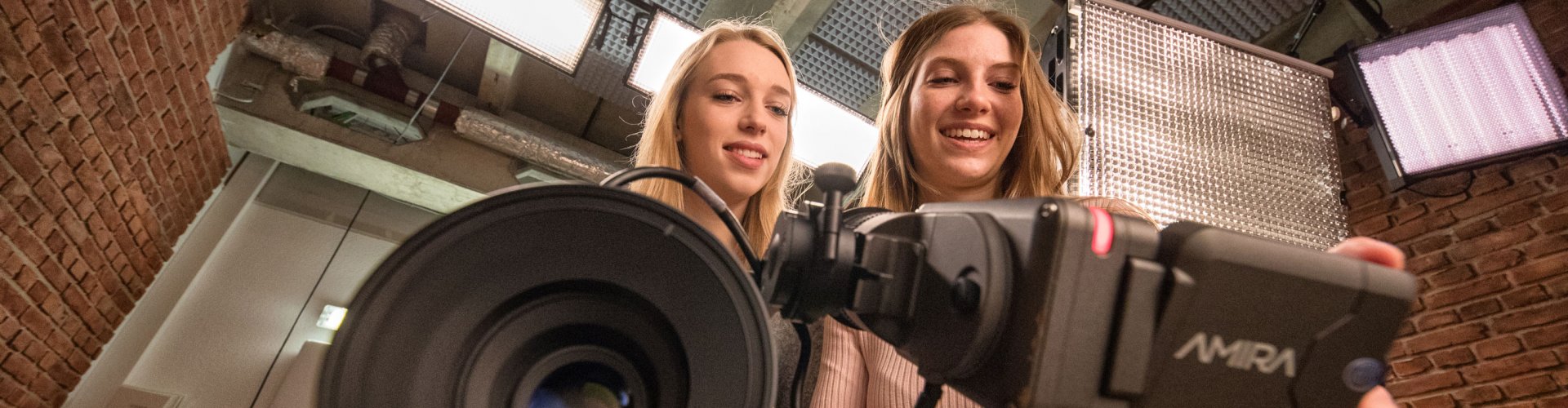 Zwei junge Frauen hinter einer Kamera.