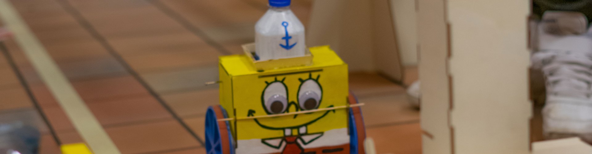 Roboter, der aussieht wie Spongebob Squarepants, auf der gefliesten Rennstrecke.