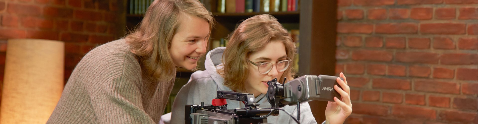 Zwei Studentinnen hinter einer Kamera.