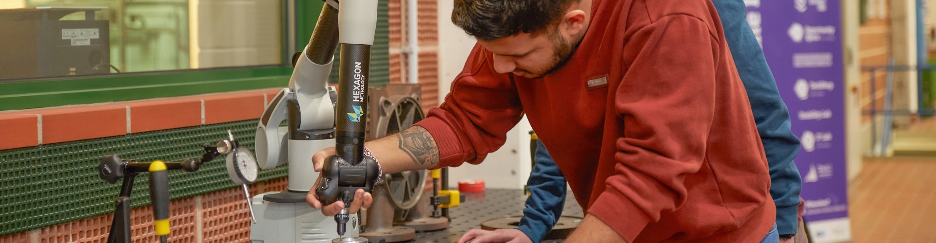 Student an einer großen Standbohrmaschine.